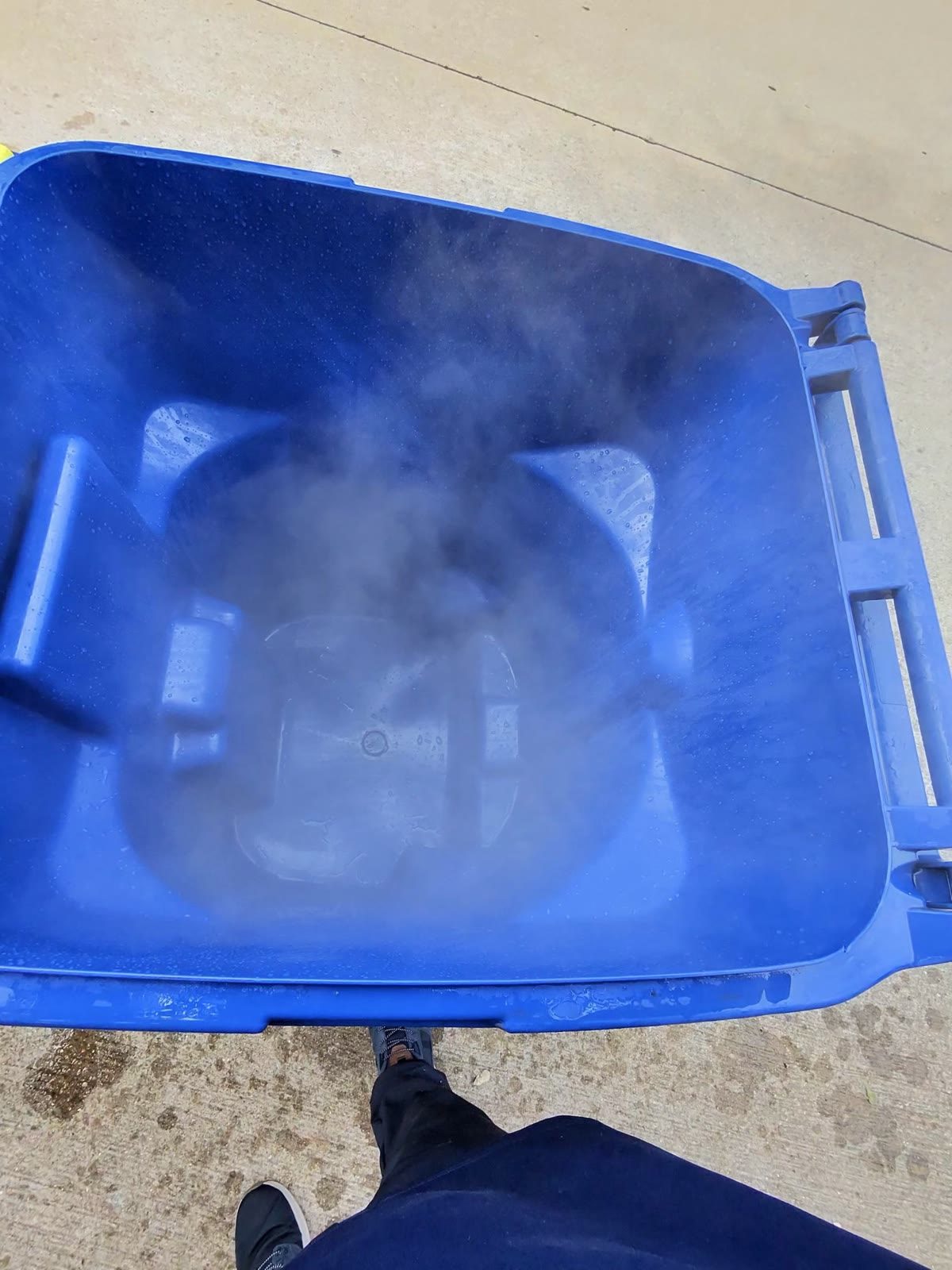 Trash can being cleaned with hot water on a truck-mounted lift in McKinney, Texas — Green Clean Machine