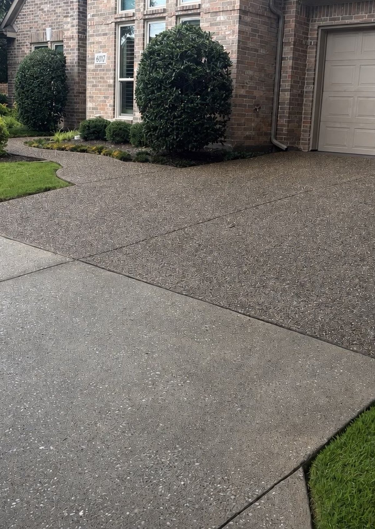 Exposed aggregate driveway darkened with dirt before hot-water pressure washing in McKinney, Texas — Green Clean Machine