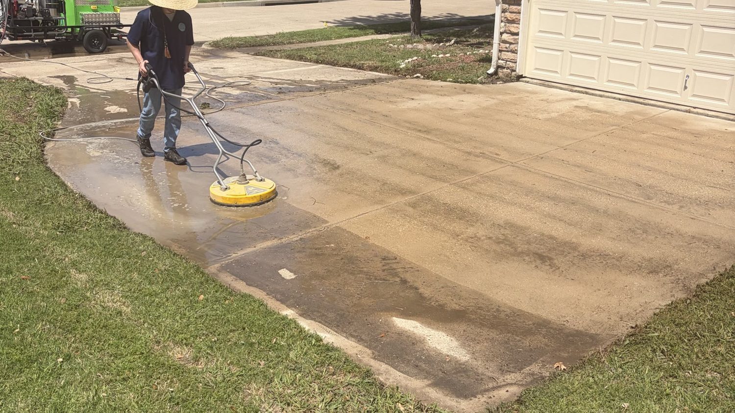 Morgan Helshoj, owner of Green Clean Machine, running a hot-water surface cleaner on a driveway in McKinney, Texas
